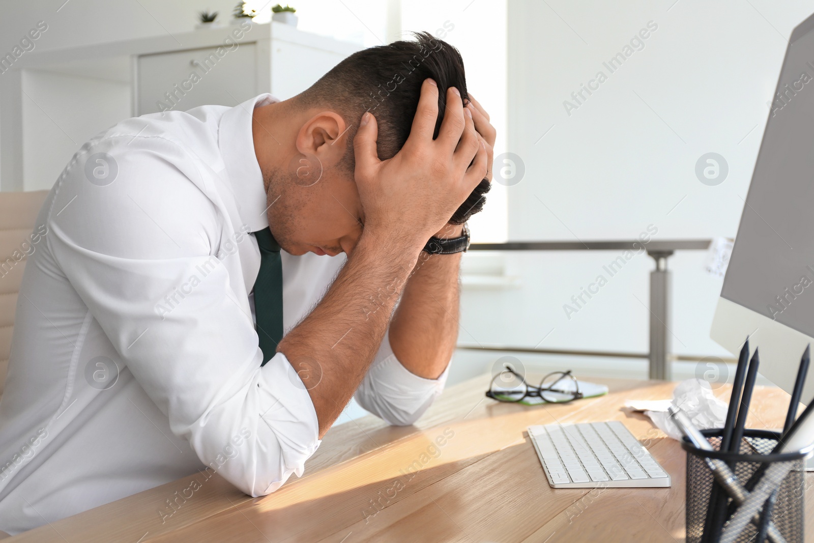 Photo of Businessman stressing out at workplace in office