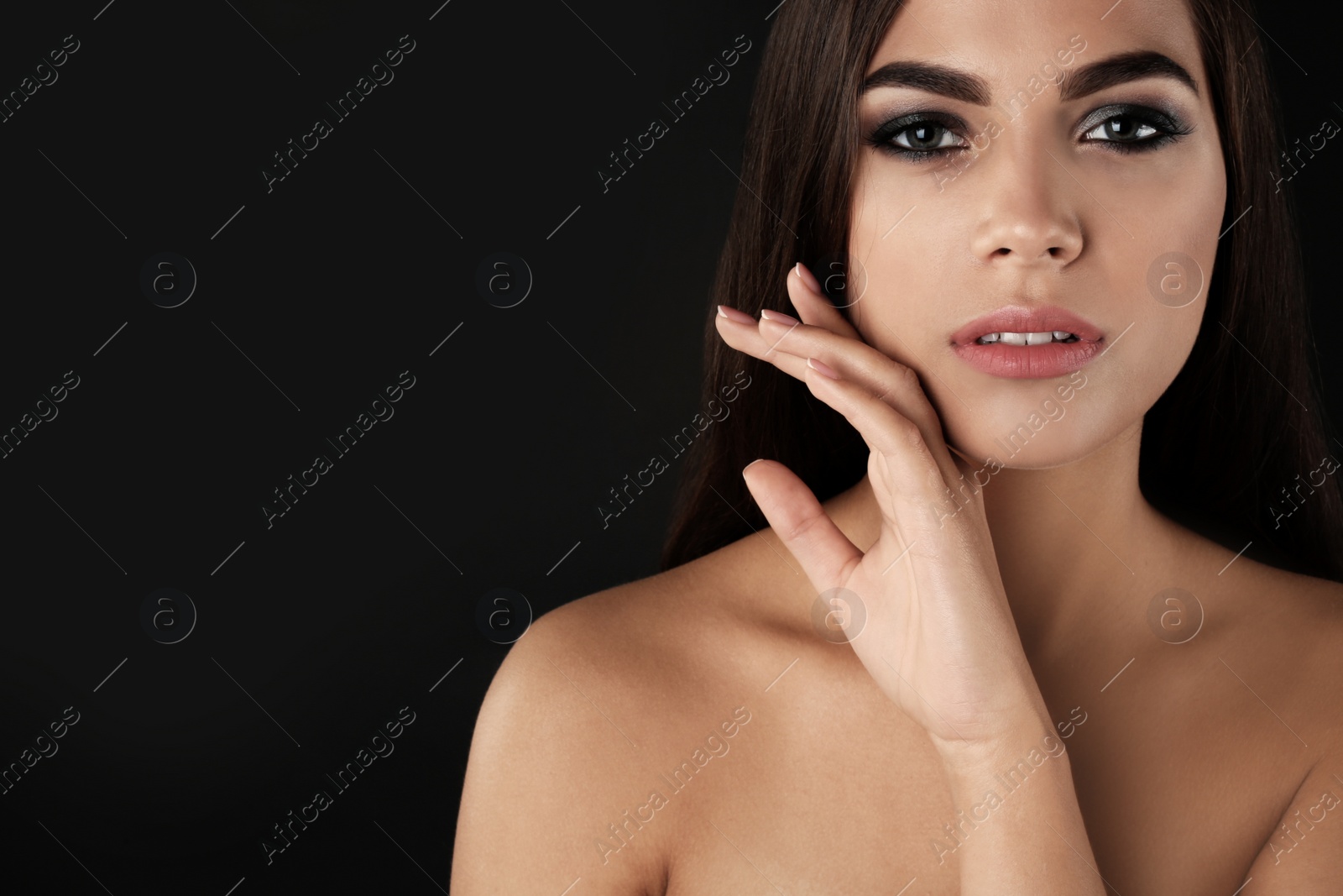 Photo of Portrait of beautiful woman with stylish makeup on dark background. Space for text