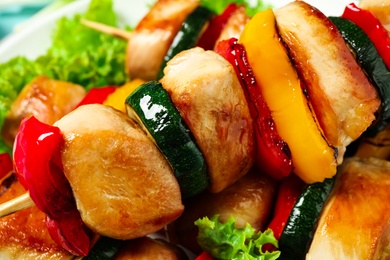 Delicious chicken shish kebabs with vegetables on plate, closeup
