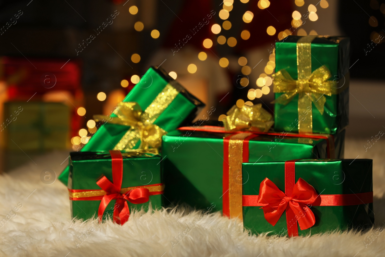 Photo of Beautiful Christmas gifts on furry carpet in room