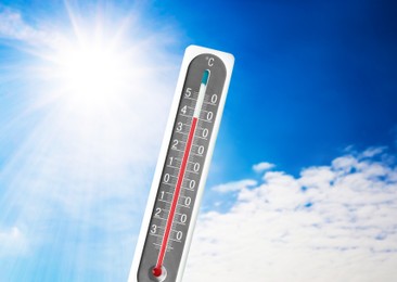 Image of Weather thermometer with high temperature outdoors on hot sunny day. Heat stroke warning