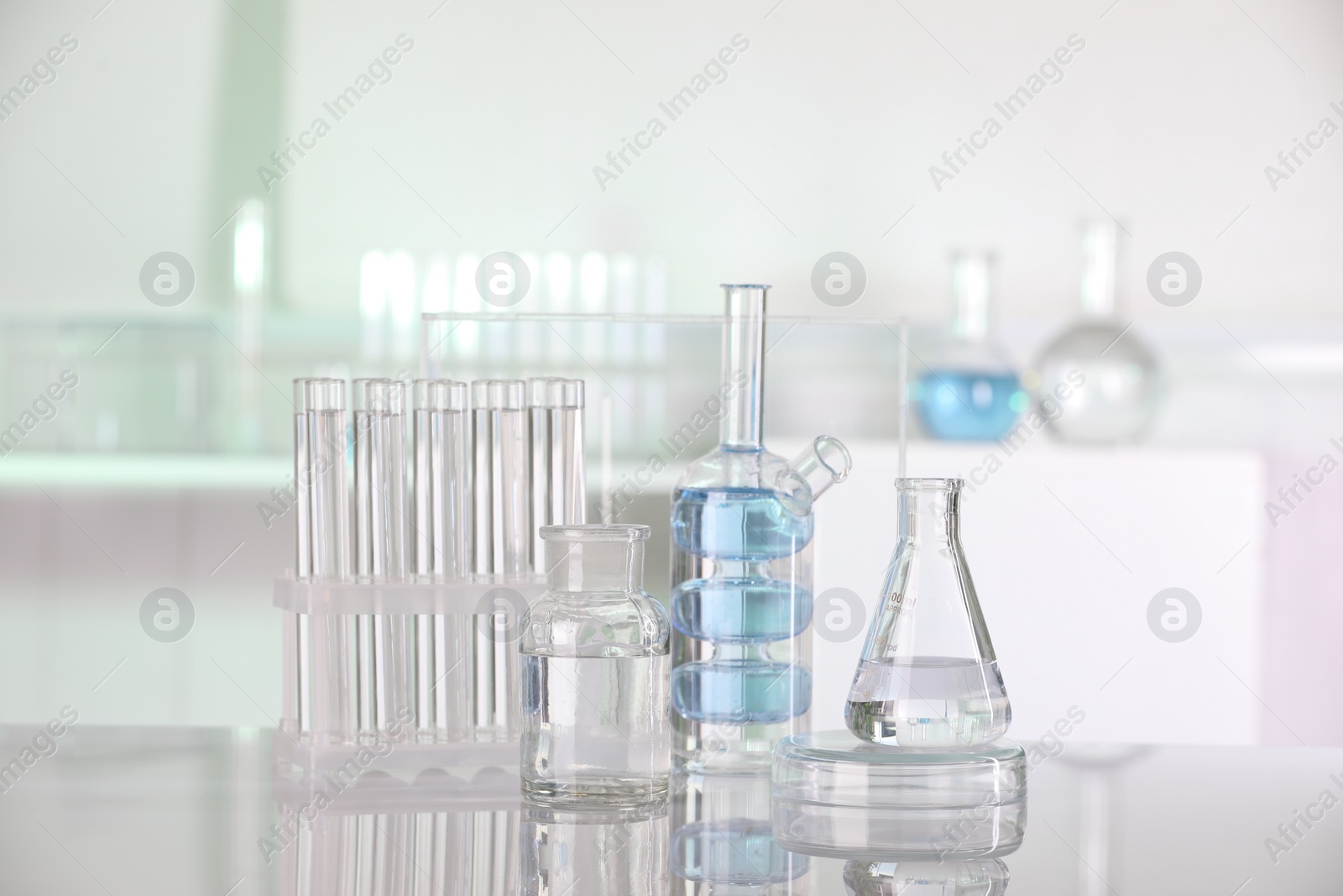 Photo of Laboratory analysis. Different glassware with liquid on white table indoors