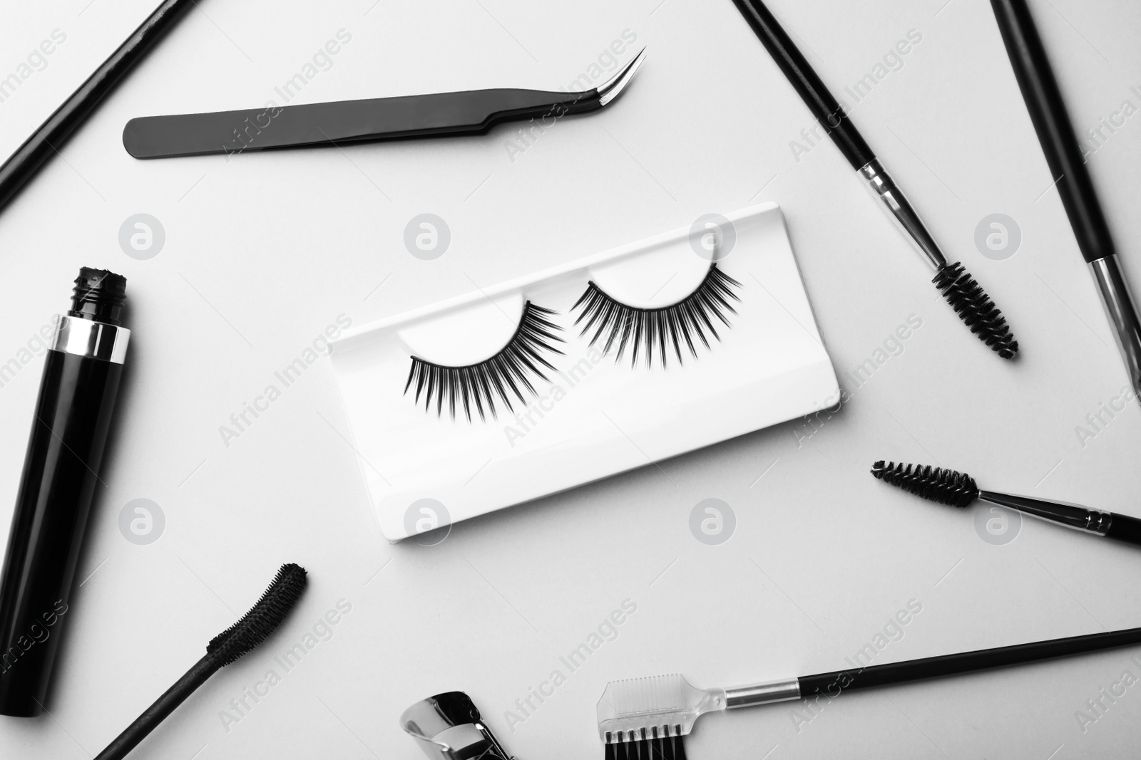 Photo of Artificial eyelashes and accessories on grey background, flat lay