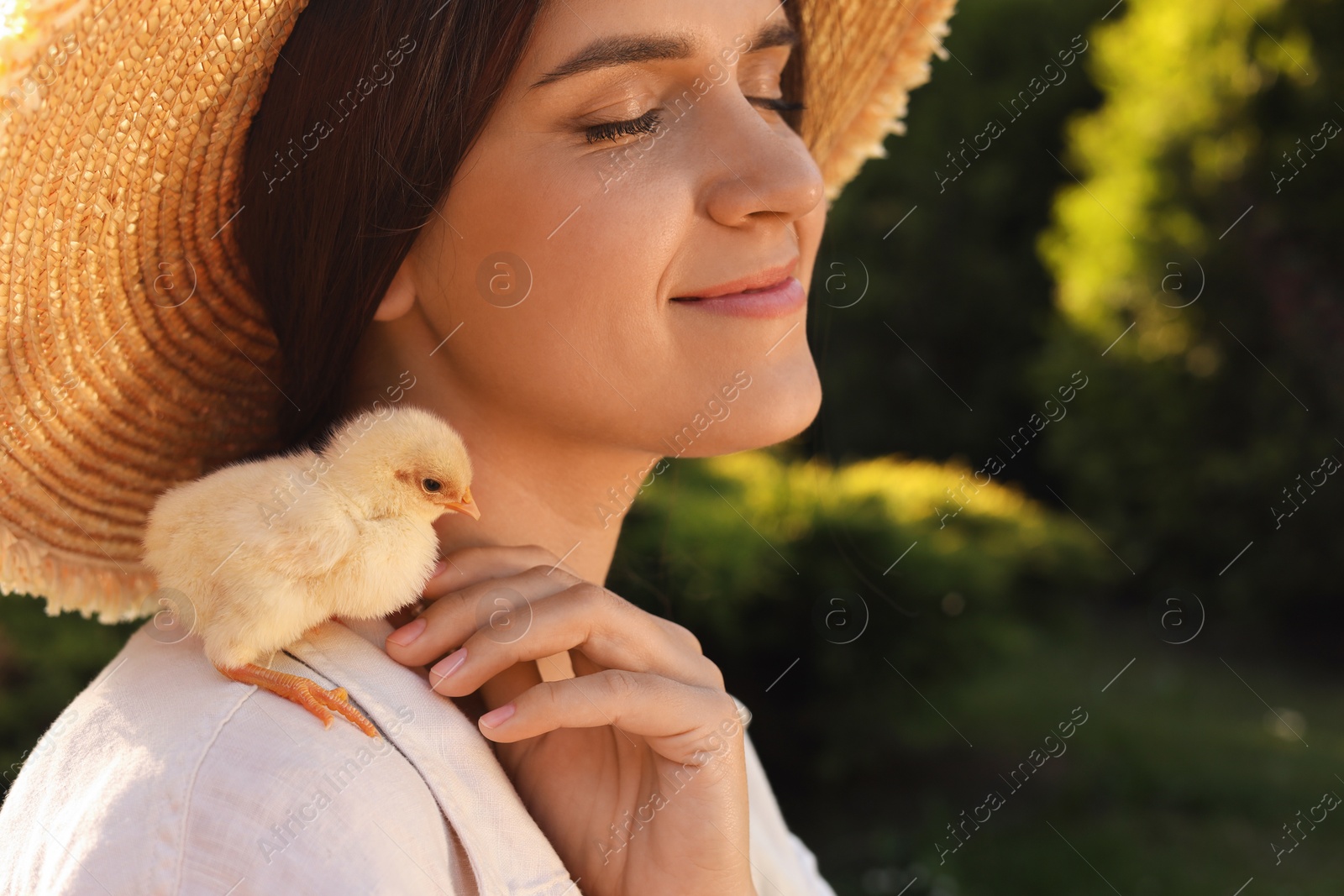 Photo of Beautiful woman with cute chick outdoors. Baby animal