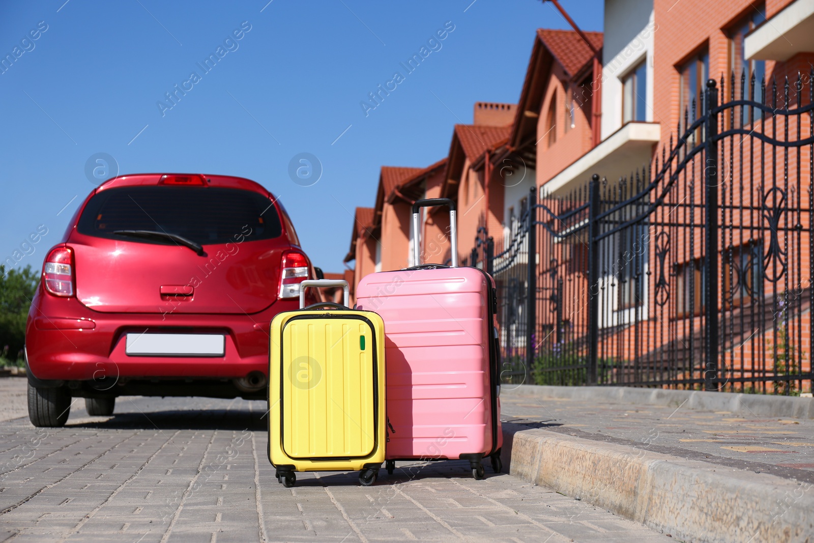 Photo of Color suitcases near family car in city. Summer vacation