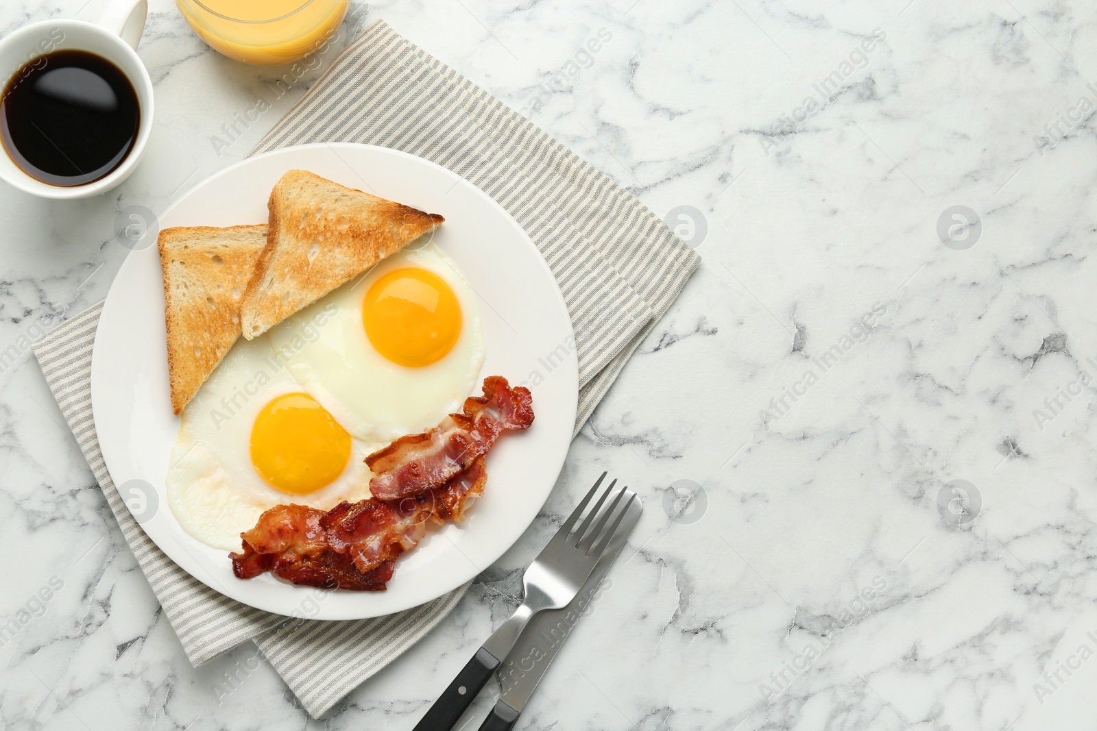 Photo of Delicious breakfast with sunny side up eggs served on white marble table, flat lay. Space for text