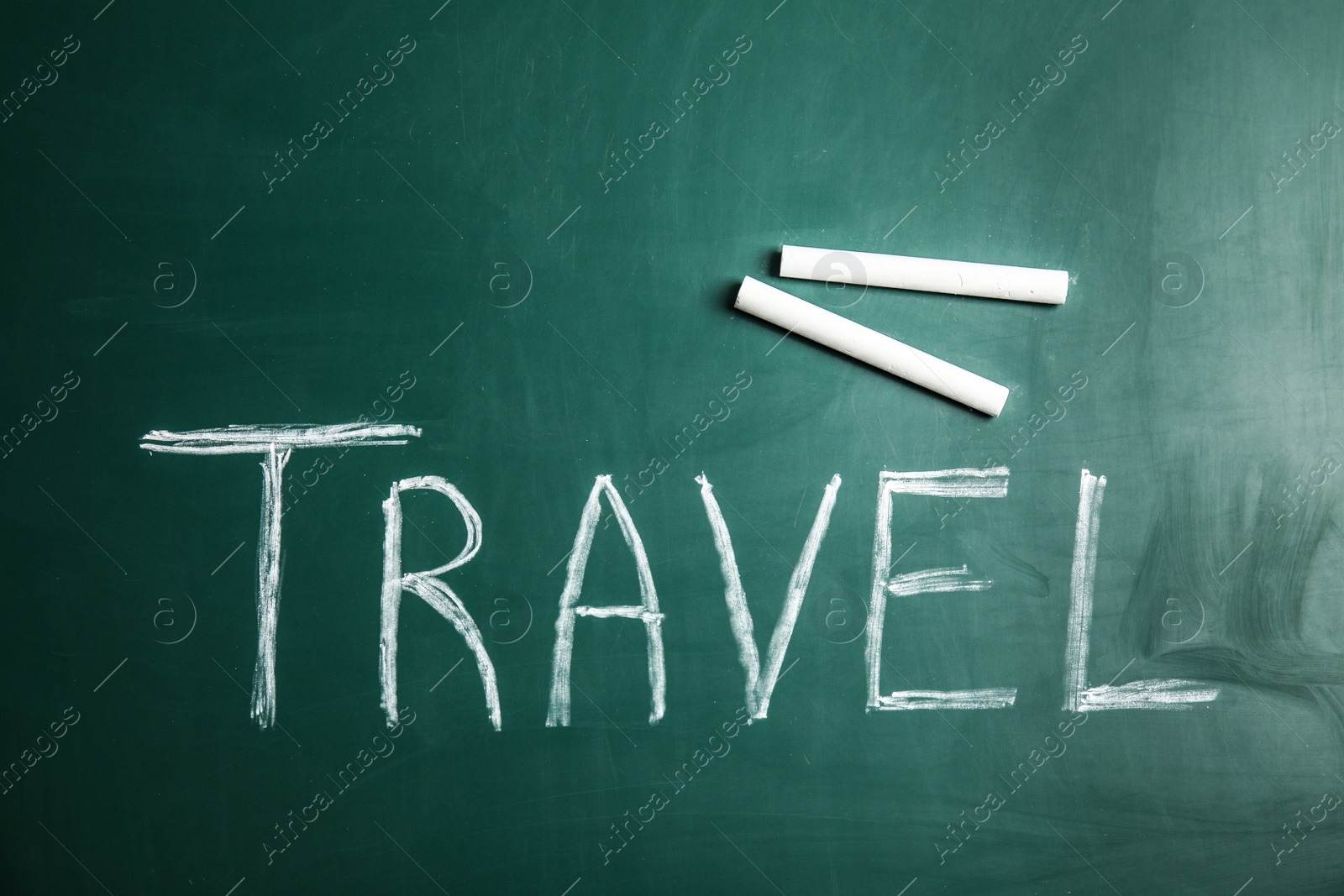 Photo of Word TRAVEL and chalk on blackboard, top view. Tourist agency