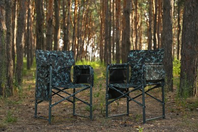 Photo of Camouflage chairs in forest on sunny day