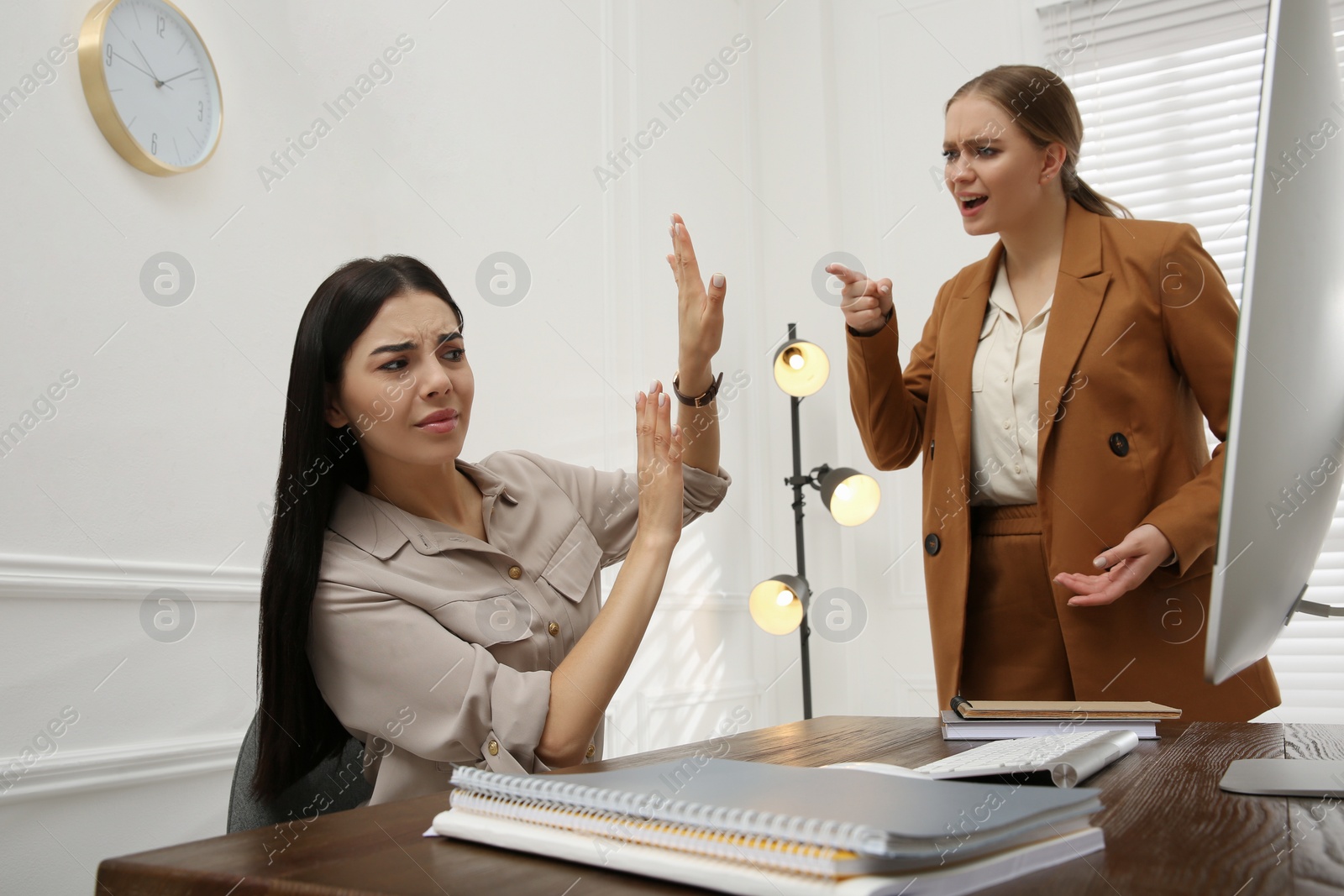 Photo of Boss screaming at employee in office. Toxic work environment