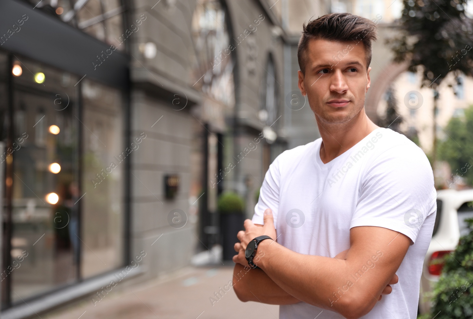 Photo of Portrait of handsome young man on city street. Space for text