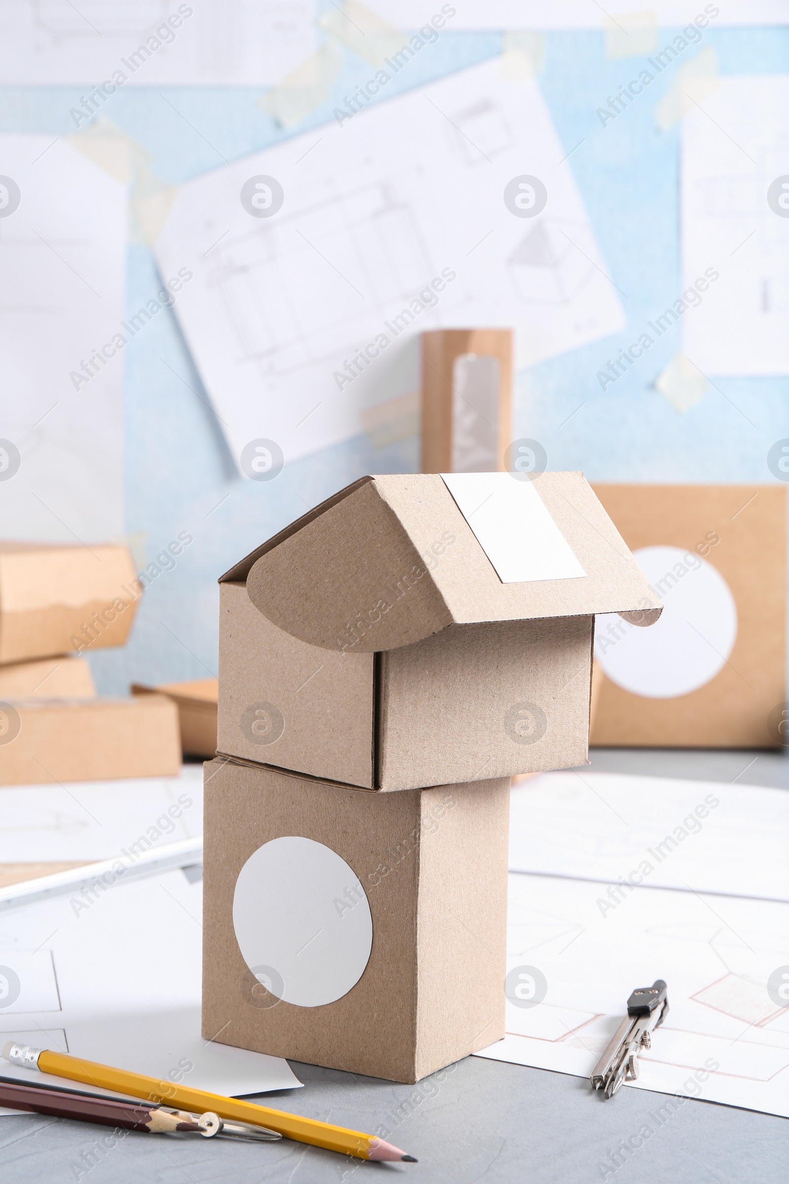 Photo of Creating packaging design. Drawings, boxes and stationery on blue textured table, closeup