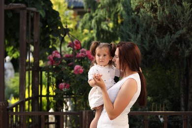 Photo of Mother with her cute daughter spending time together in park