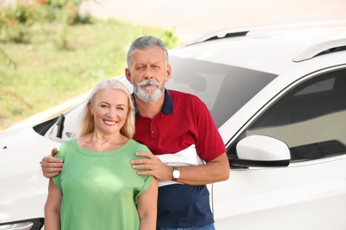 Photo of Happy senior couple standing near car outdoors