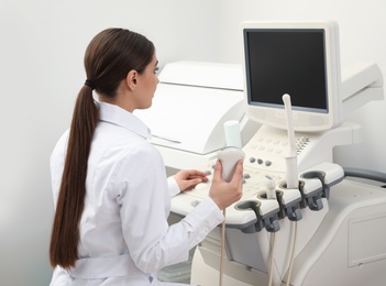 Professional sonographer using modern ultrasound machine in clinic