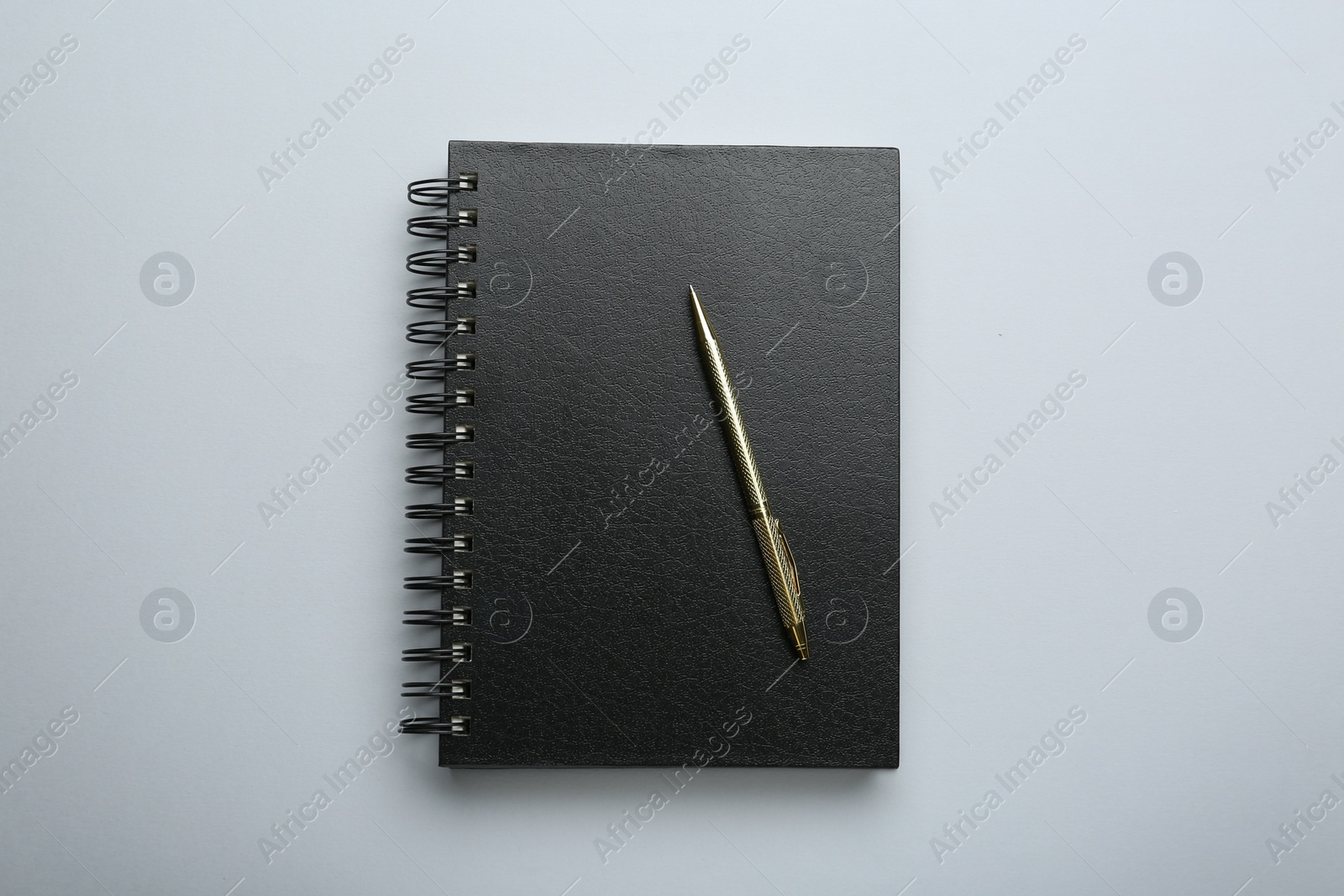 Photo of One notebook and pen on light grey background, top view