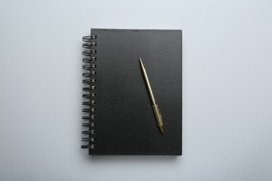 One notebook and pen on light grey background, top view