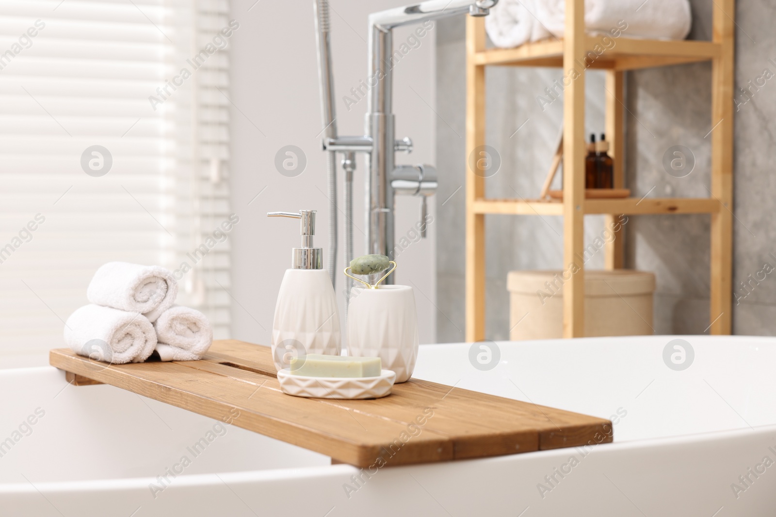 Photo of Different personal care products on bath tub in bathroom