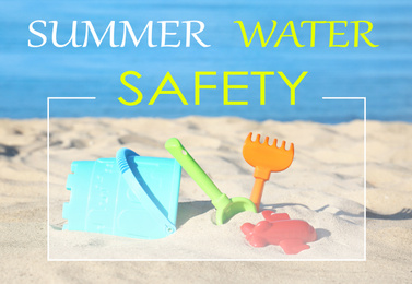 Summer water safety. Set of plastic beach toys on sand near sea