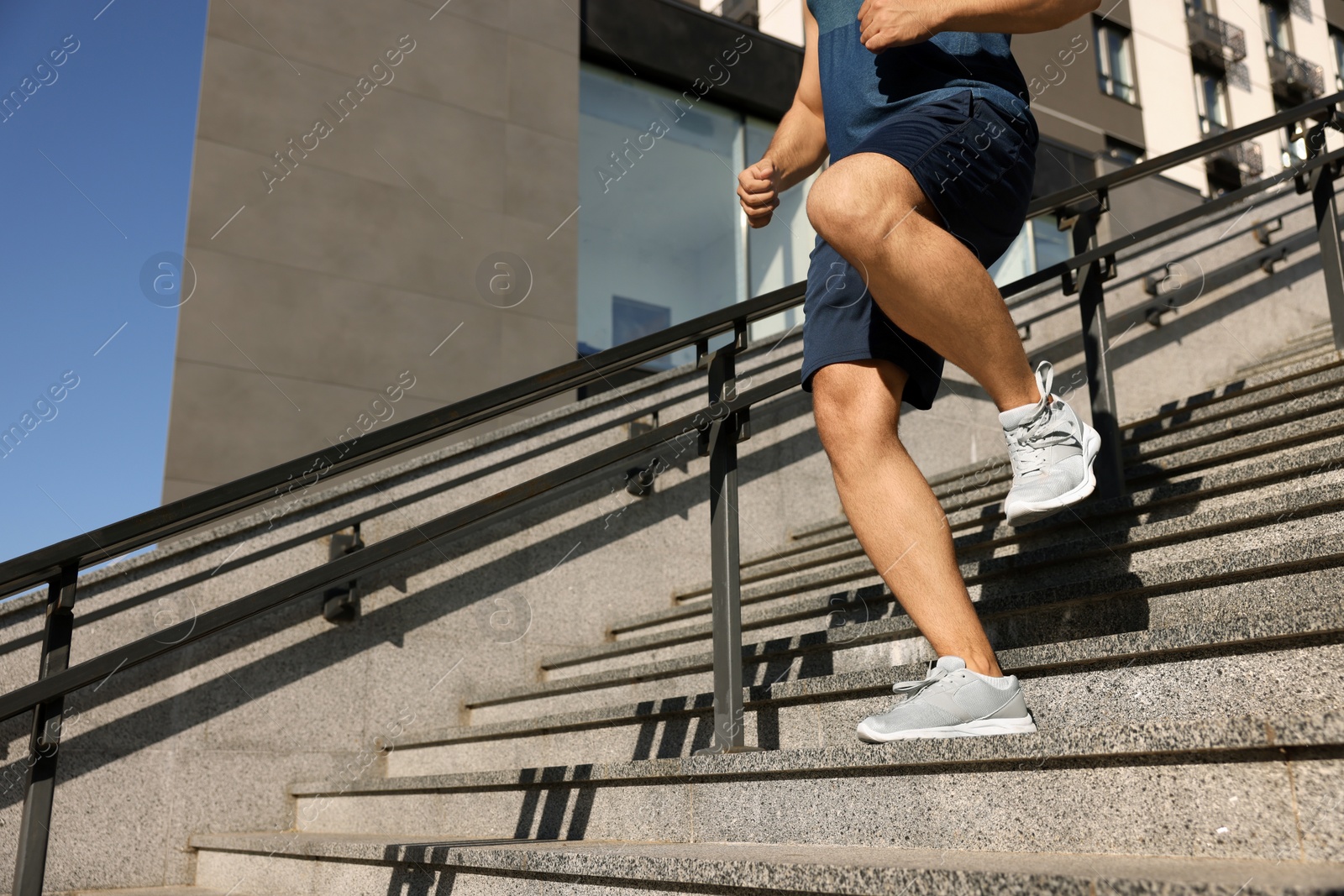 Photo of Man running down stairs outdoors on sunny day, closeup. Space for text