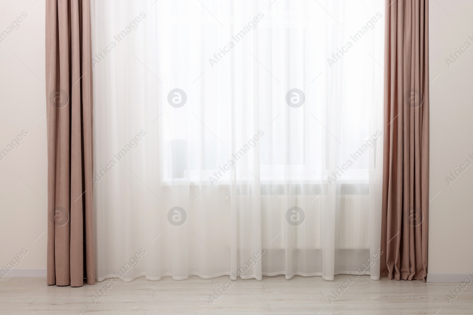 Photo of Elegant window curtains and white tulle indoors. Interior design