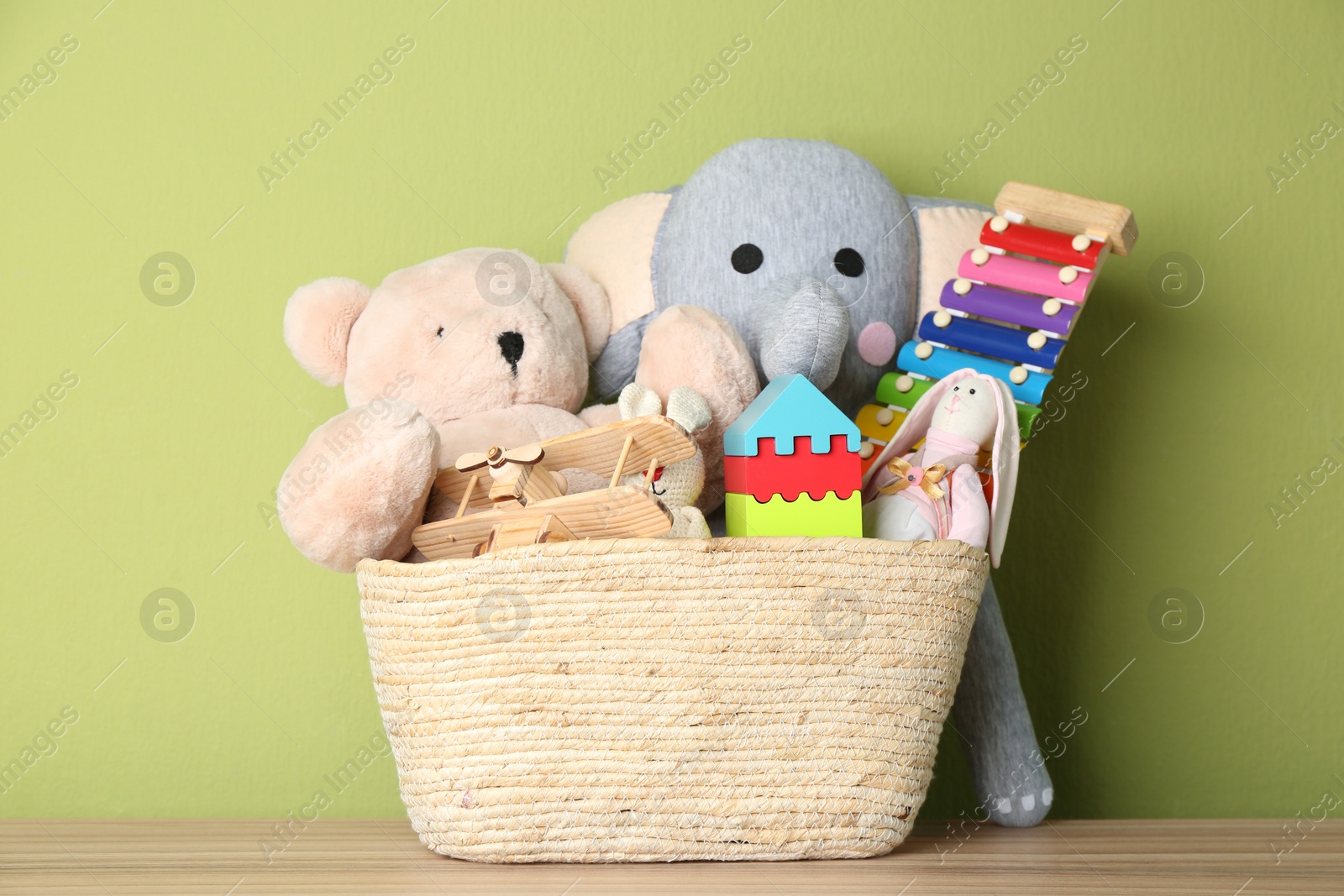 Photo of Basket with different toys on wooden table