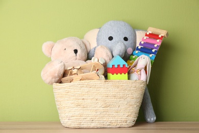 Photo of Basket with different toys on wooden table