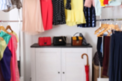 Blurred view of dressing room with different clothes and accessories