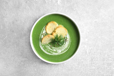 Photo of Fresh vegetable detox soup with croutons in dish on table, top view