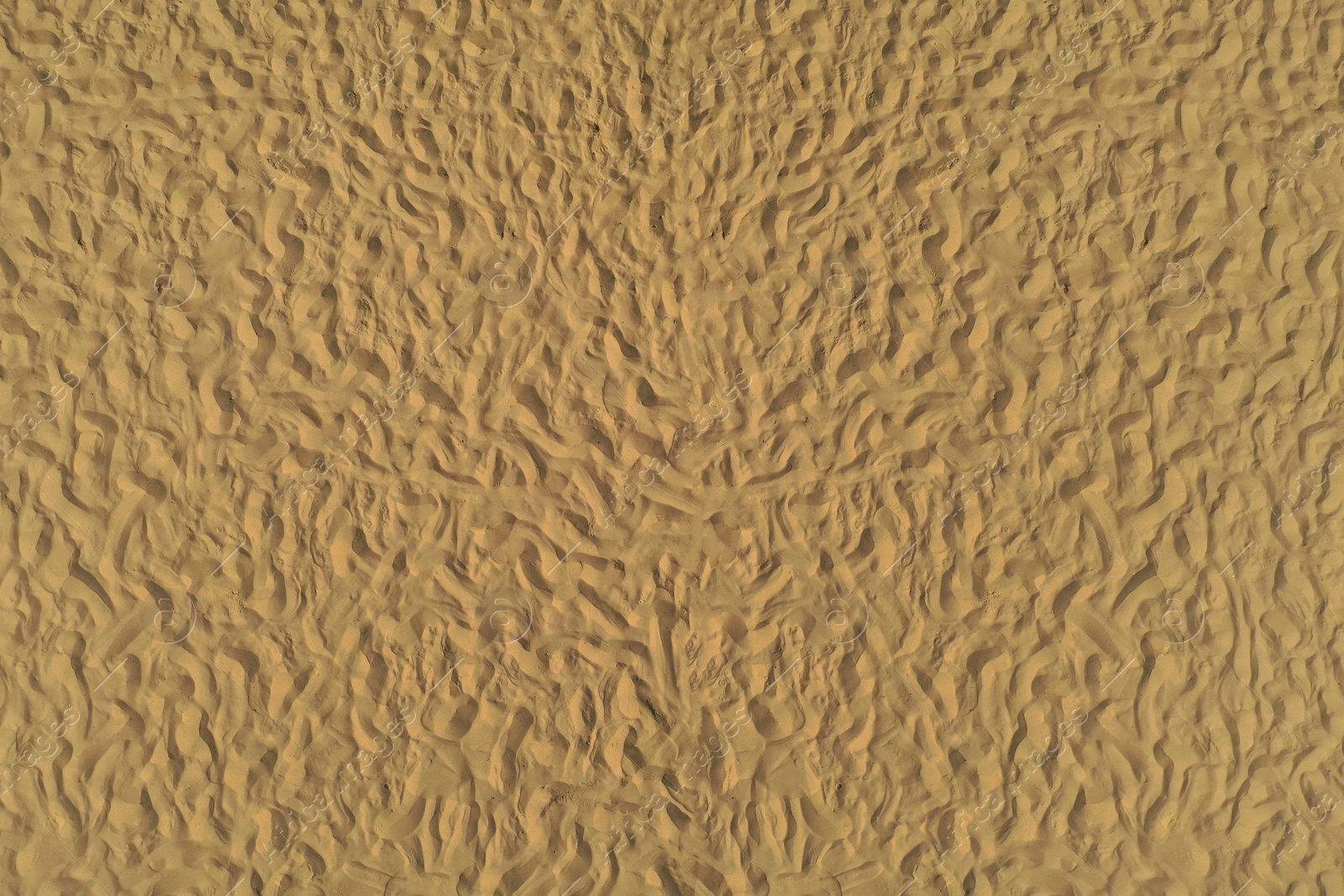 Photo of Golden beach sand on sunny day as background, top view