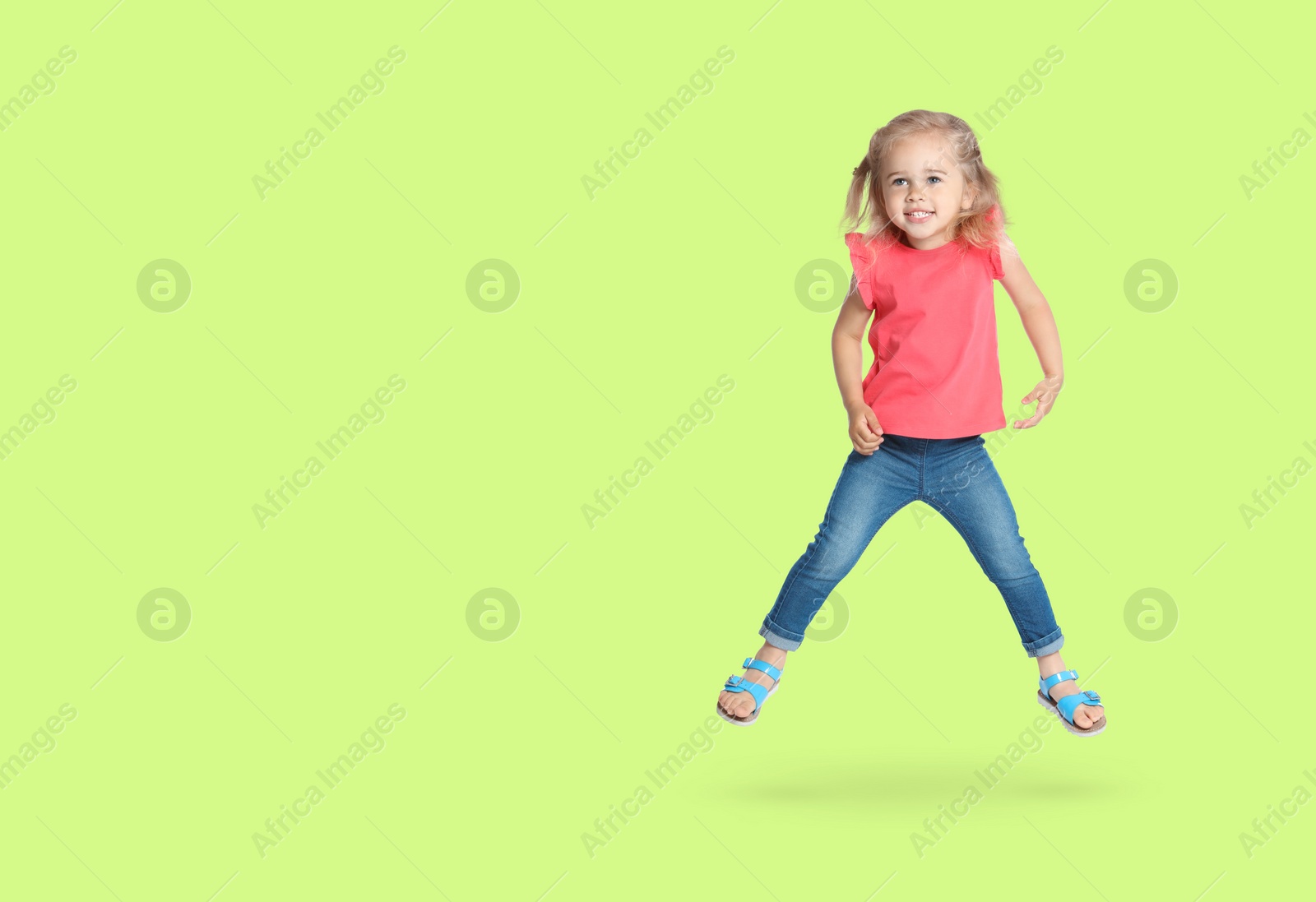 Image of Cute girl jumping on light green background, space for text