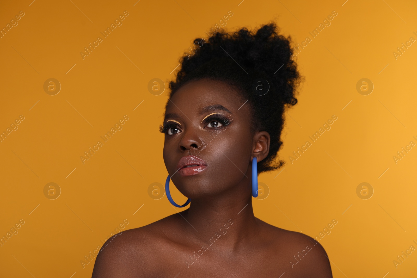 Photo of Fashionable portrait of beautiful woman with makeup on orange background