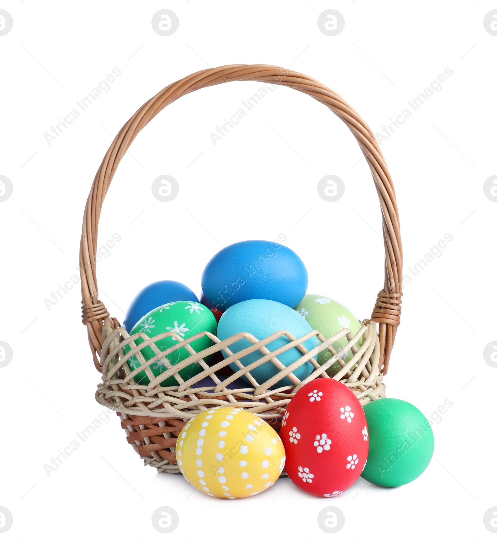 Photo of Wicker basket with bright painted Easter eggs on white background