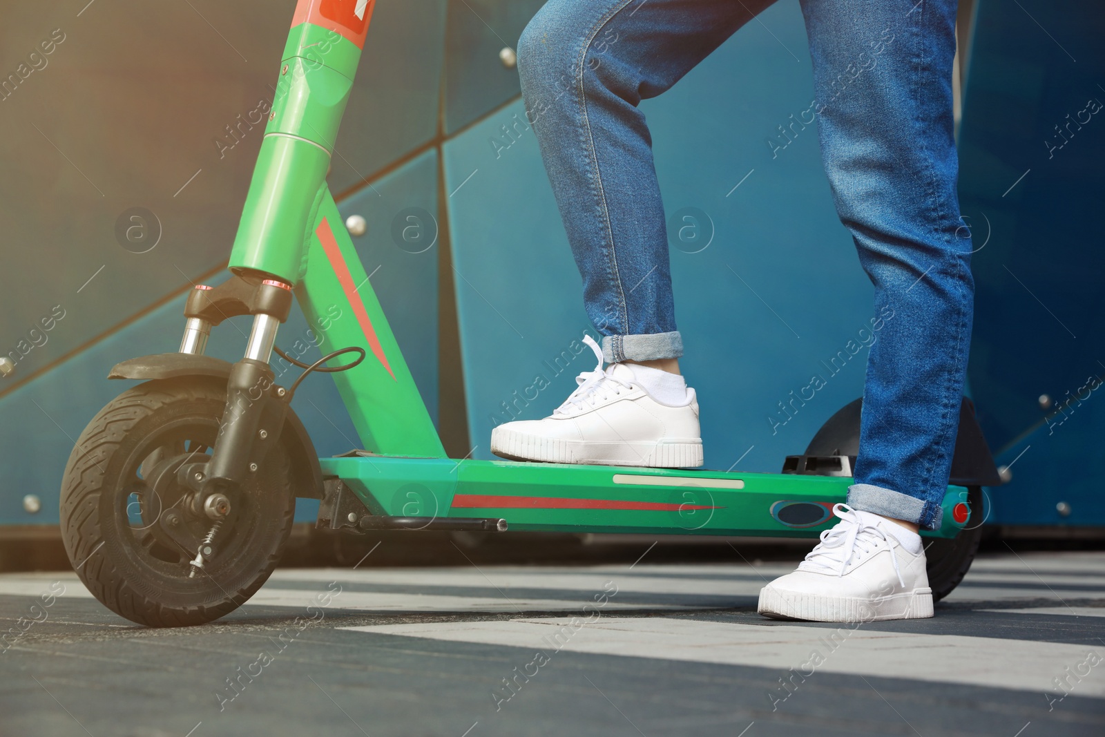 Photo of Woman with modern electric kick scooter outdoors, closeup