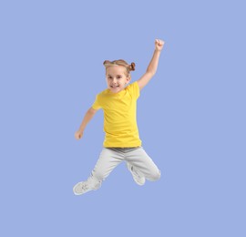 Image of Happy cute girl jumping on light blue background