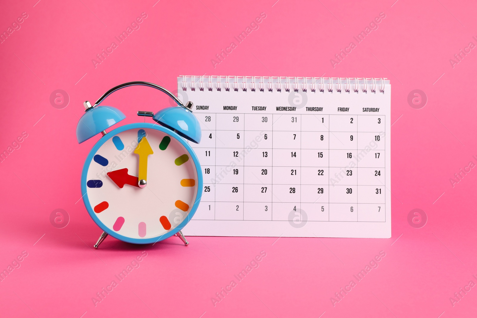 Photo of Alarm clock and calendar on pink background. Reminder concept