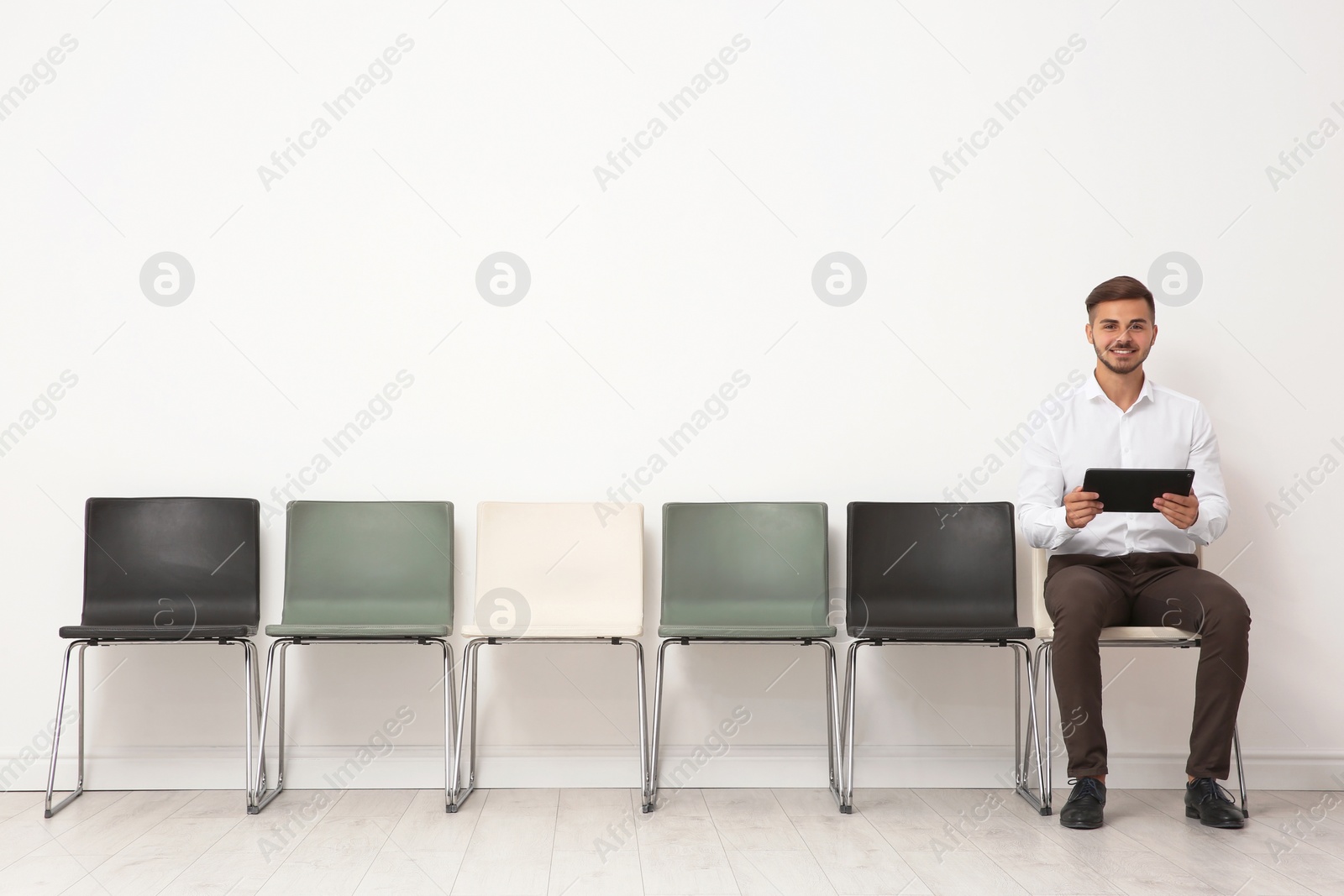 Photo of Young man sitting on chair and waiting for job interview