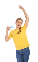 Happy young woman with driving license on white background