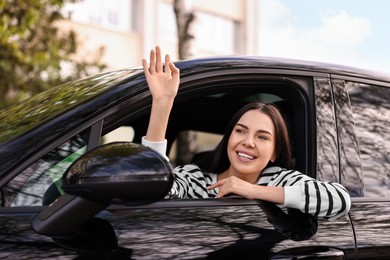 Photo of Young woman sitting inside her modern car