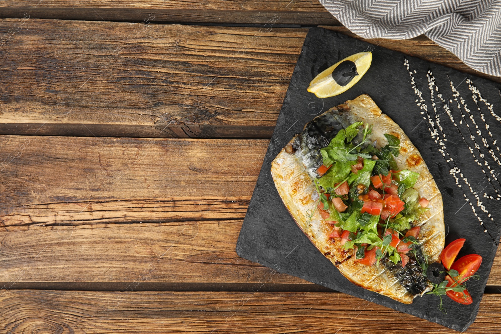 Photo of Delicious grilled fish served on wooden table, flat lay. Space for text