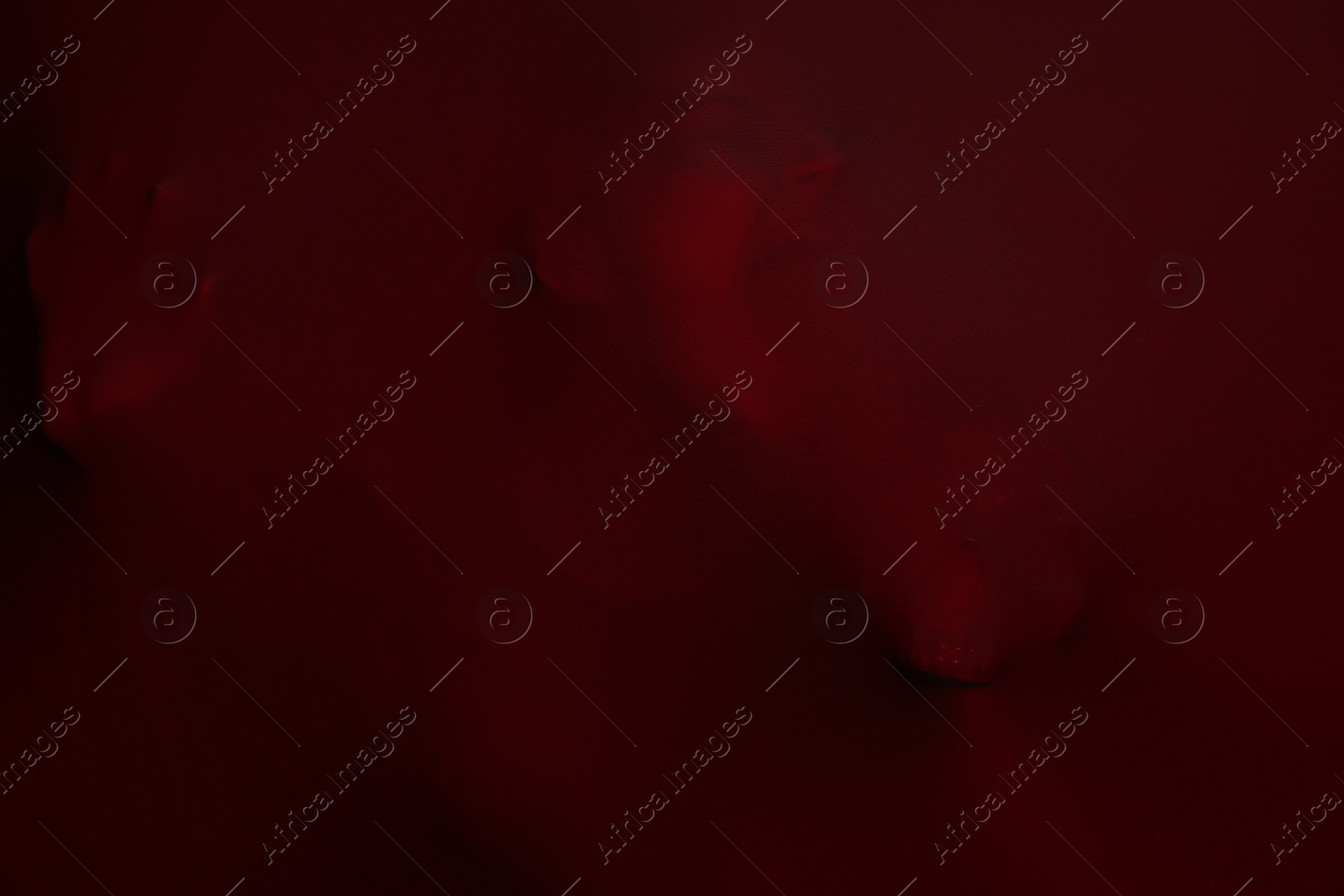 Photo of Silhouette of creepy ghost with skull behind red cloth