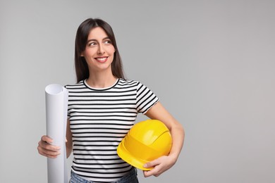 Architect with hard hat and draft on light grey background, space for text