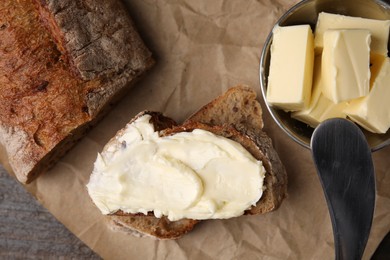 Photo of Tasty bread with butter and knife on table, flat lay