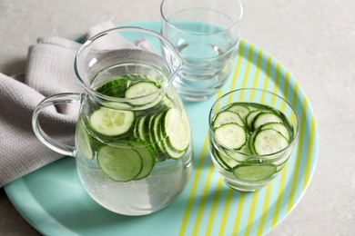 Photo of Glasses and jug of fresh cucumber water on tray