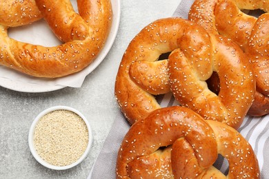 Tasty freshly baked pretzels on light grey table, flat lay