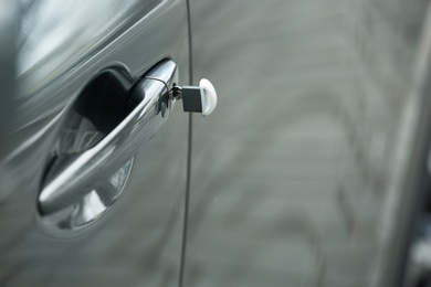 Closeup view of car door with key in lock. Space for text