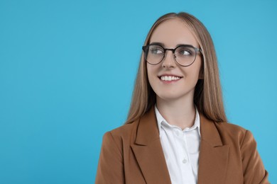 Photo of Portrait of happy young secretary on light blue background, space for text