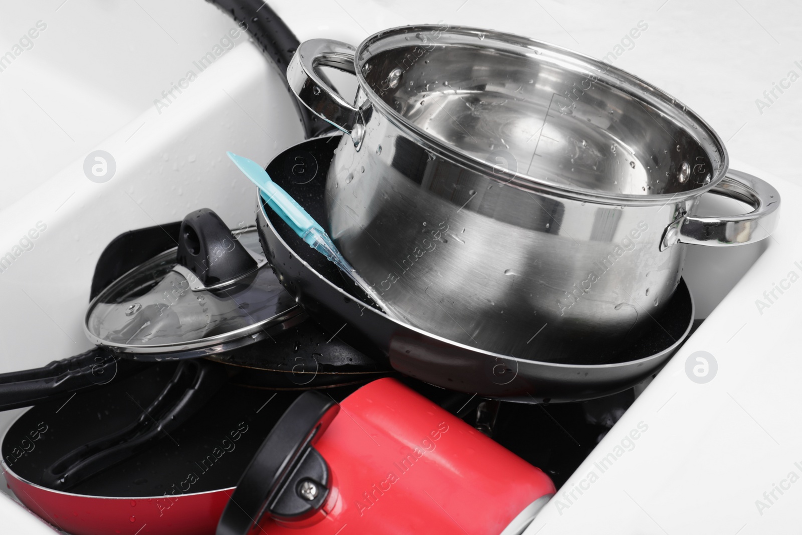 Photo of Messy pile of clean kitchenware in sink, closeup