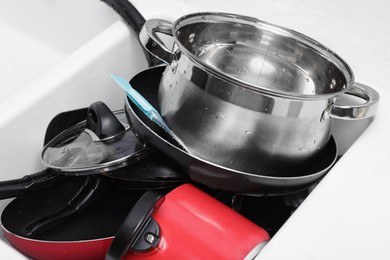 Messy pile of clean kitchenware in sink, closeup