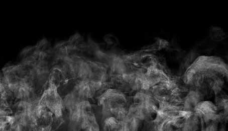 White steam rising in air on black background