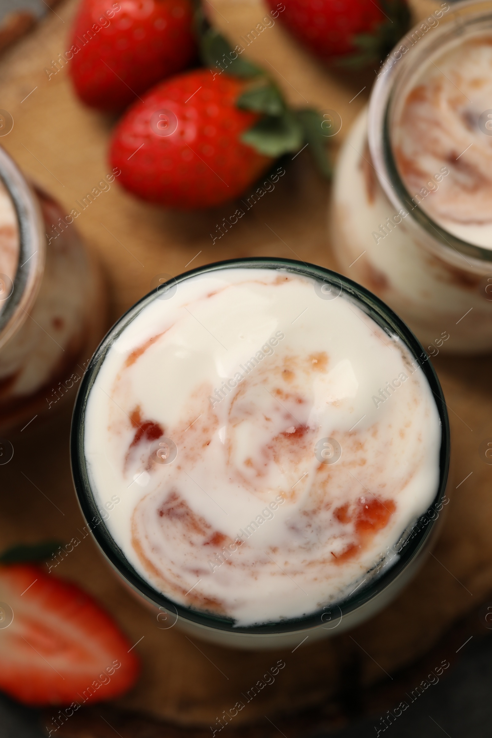 Photo of Tasty yoghurt with jam and strawberries on table, top view